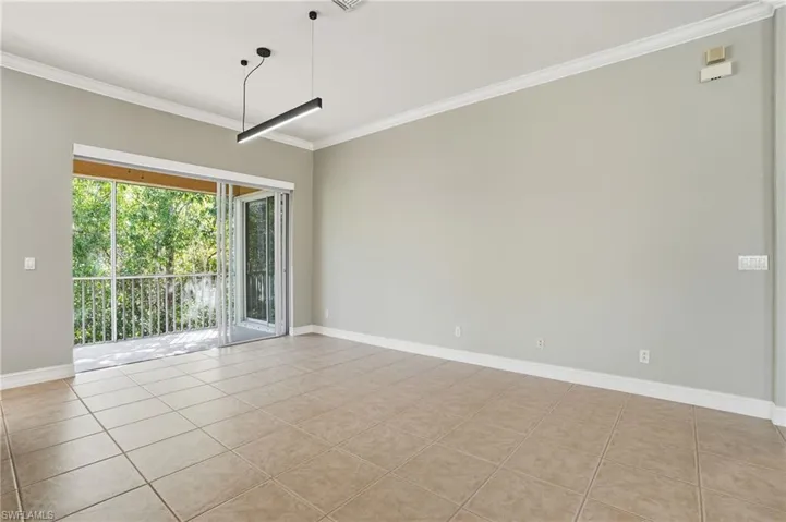 Empty room featuring ornamental molding and light tile patterned flooring