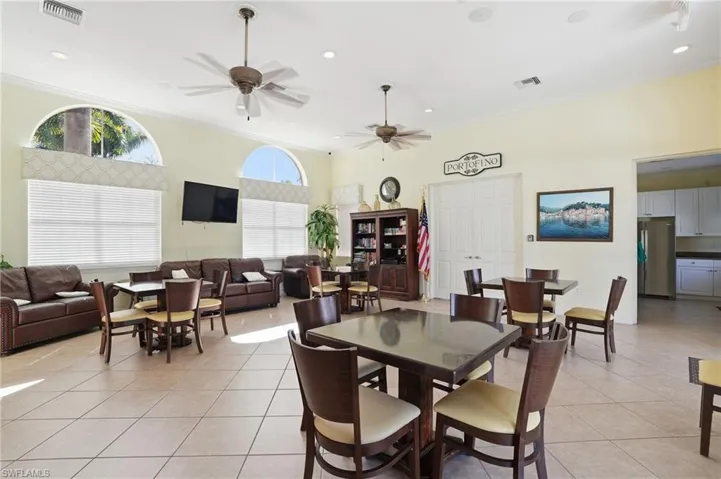 Dining room with ornamental molding, light tile patterned floors, ceiling fan, recessed lighting, and a high ceiling