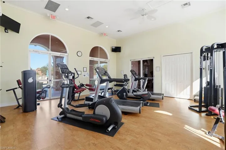 Gym featuring crown molding, a ceiling fan, a high ceiling, and recessed lighting