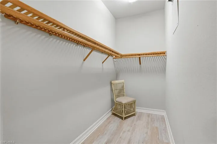 Walk in closet with light wood finished floors