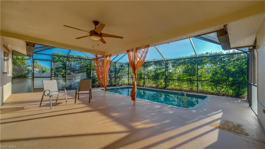 View of pool with ceiling fan, a lanai, and a patio area
