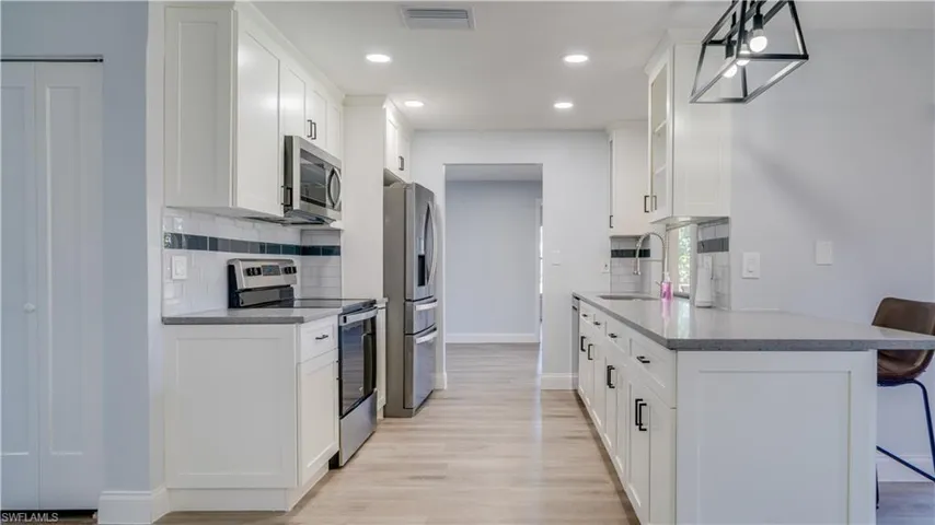 Brand new kitchen updates with white shaker style cabinets, sparkly gray quartz counters, and brand new stainless steel range, microwave and dishwasher. Pass through window with bar seating on the pool deck