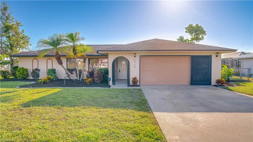 View of front facade featuring a garage and a front yard