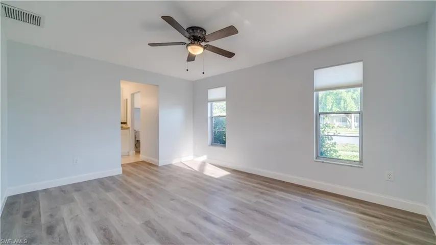 Main family room in the rear of the room. Full of beautiful natural light! New ceiling fan, fresh coat of paint, new baseboards and new luxury plank vinyl flooring.