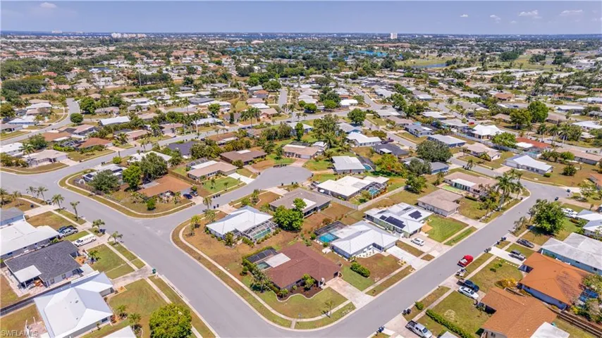 Rear aerial shows off the oversized corner lot this pool home sits on. With a nice screened in lanai, you can enjoy the beautiful weather without dealing with the bugs. A nice line of hedges along the pool cage perimeter gives you privacy!