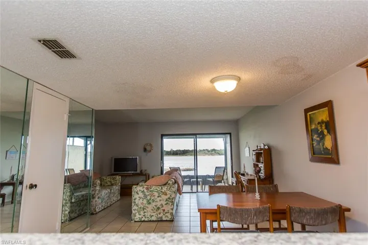 Living area with light tile patterned floors, visible vents, and a textured ceiling