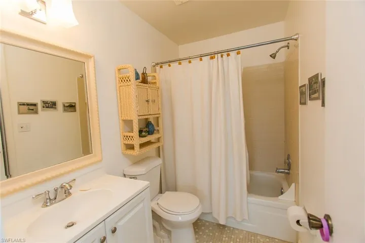 Full bath with vanity, shower / bath combination with curtain, and toilet