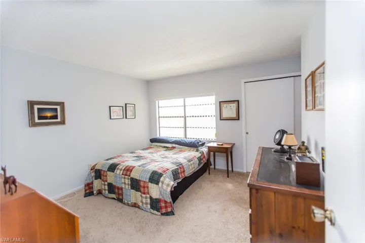 Carpeted bedroom featuring baseboards and a closet
