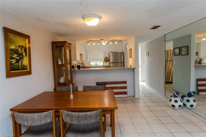 Dining area with visible vents, a textured ceiling, and light tile patterned flooring