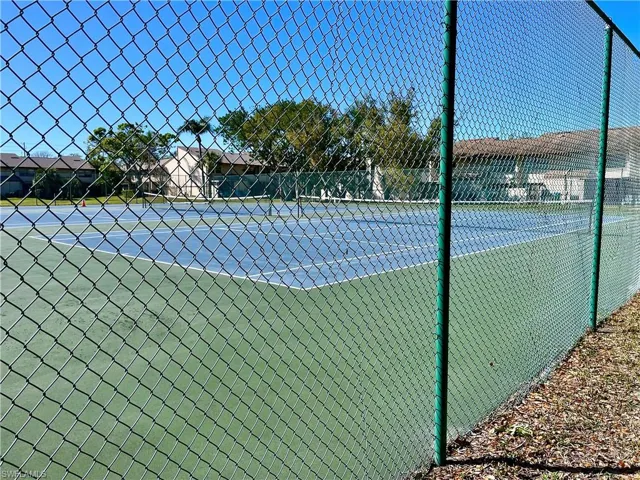 View of tennis court featuring fence