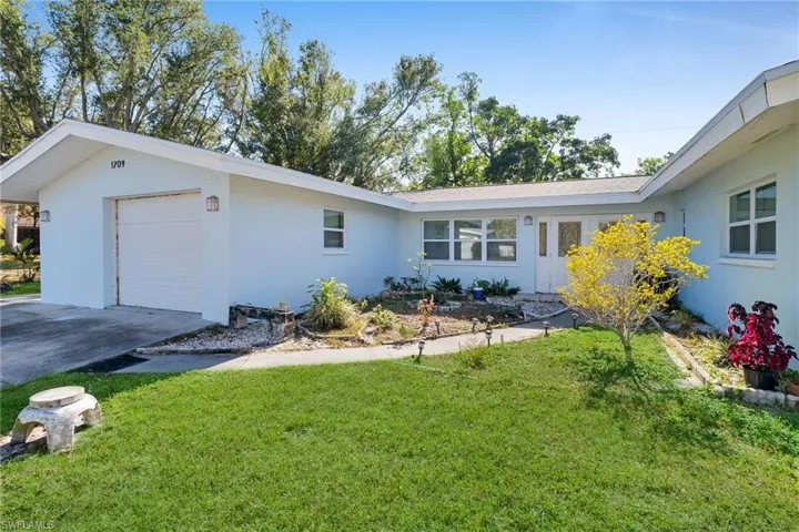 View of front of house featuring a front yard and a garage