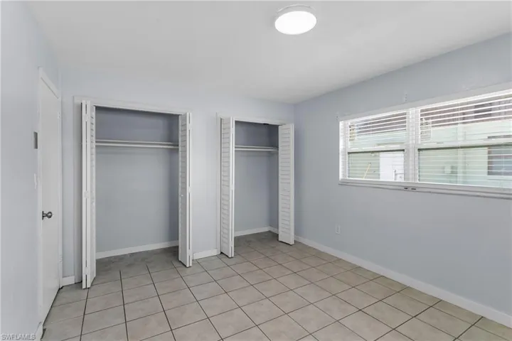 Unfurnished bedroom featuring two closets and light tile patterned flooring