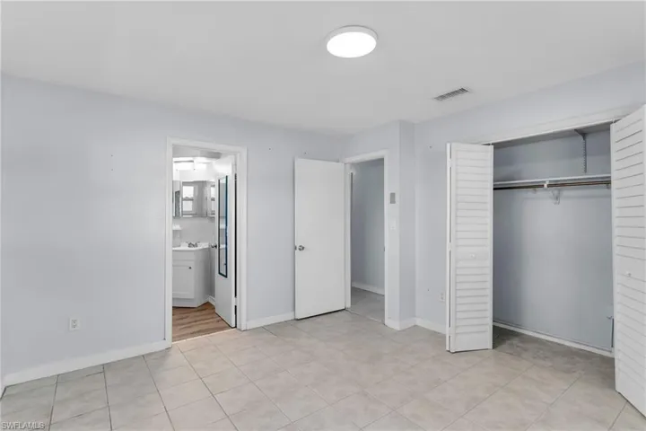 Unfurnished bedroom with ensuite bath, a closet, and sink