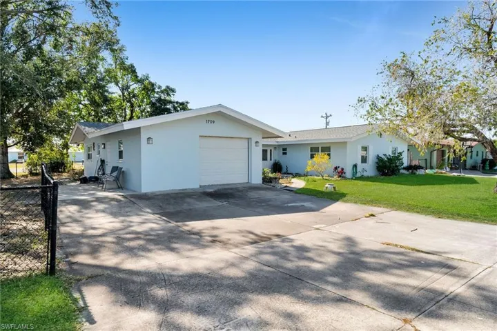 Single story home featuring a front yard and a garage