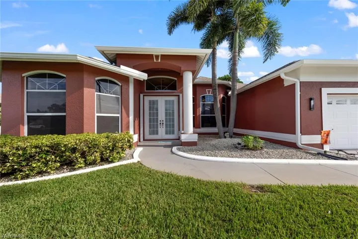 Ranch-style house featuring a garage, central AC unit, and a front yard