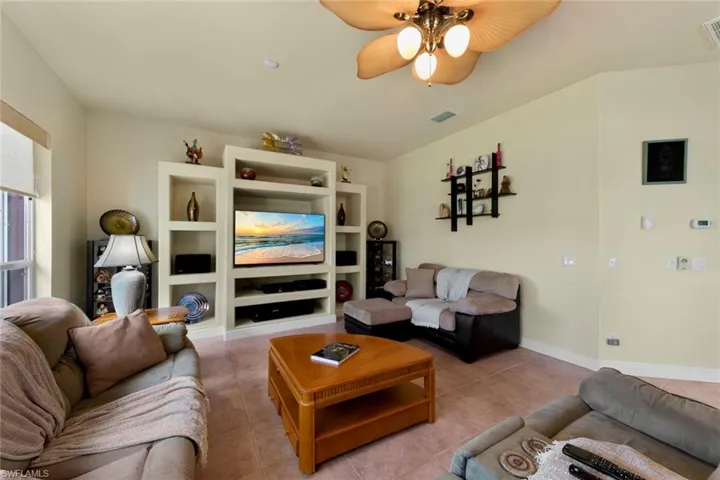 Living room with light tile patterned floors and ceiling fan