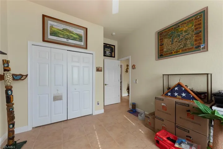 Bedroom with a closet, ceiling fan, and light tile patterned floors