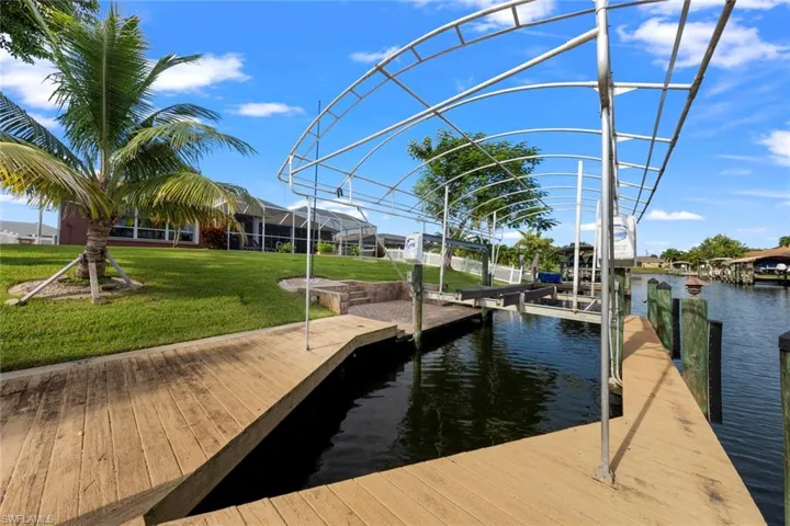 View of dock with a water view and a yard