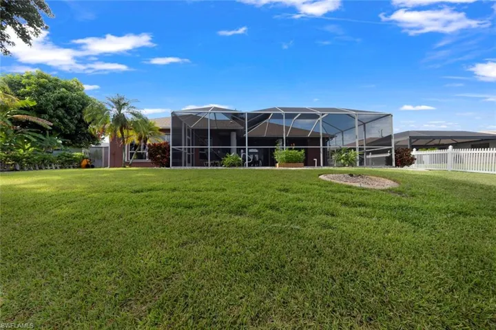 Rear view of property featuring a yard and a lanai