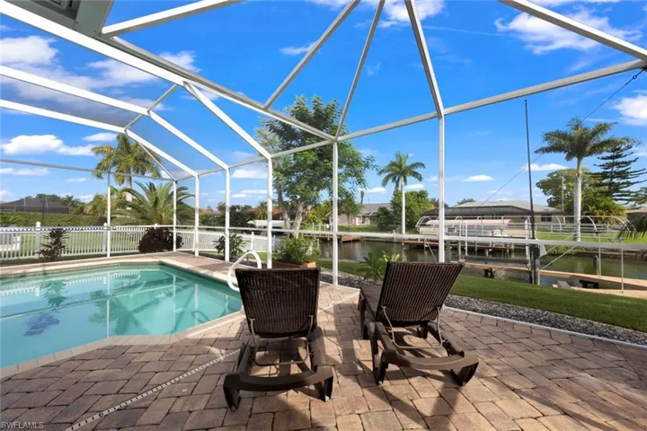 View of swimming pool featuring a water view, a lanai, and a patio area
