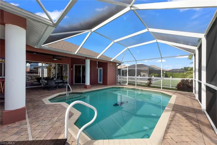 View of pool featuring ceiling fan, a patio, and glass enclosure