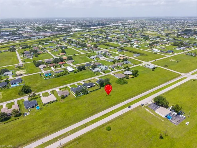 Aerial view of property and surrounding area featuring nearby suburban area