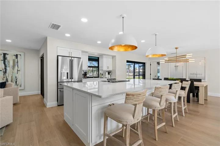 Massive kitchen island featuring designer lighting fixtures     (Photo digitally enhanced)