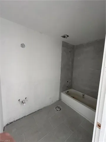 Full bath with tub / shower combination and tile patterned flooring
