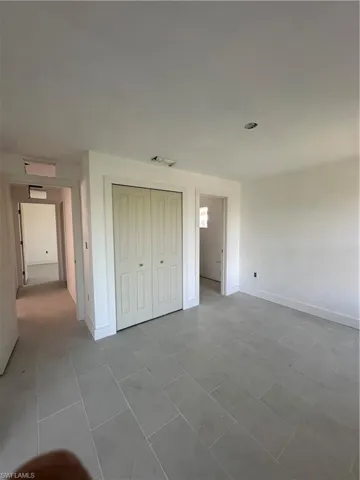 Unfurnished bedroom with a closet and light tile patterned floors