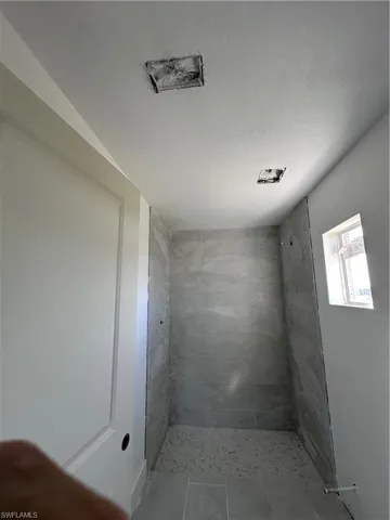 Bathroom with a shower stall and a textured ceiling