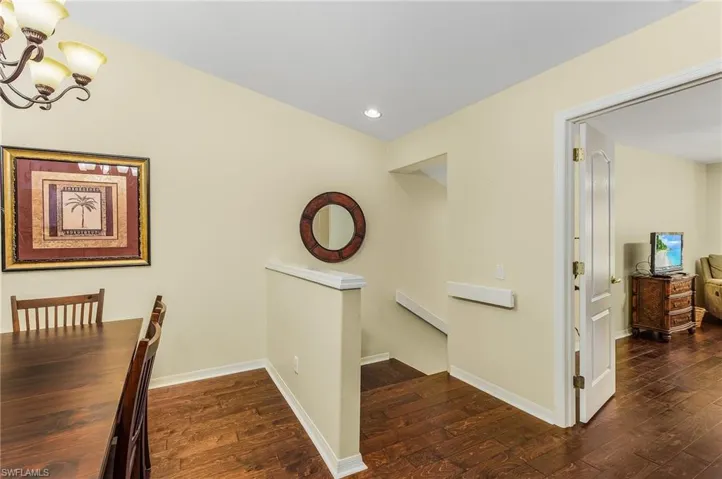 Hallway featuring a notable chandelier and dark wood-type flooring
