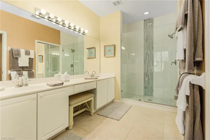 Bathroom with tile patterned flooring, vanity, and walk in shower