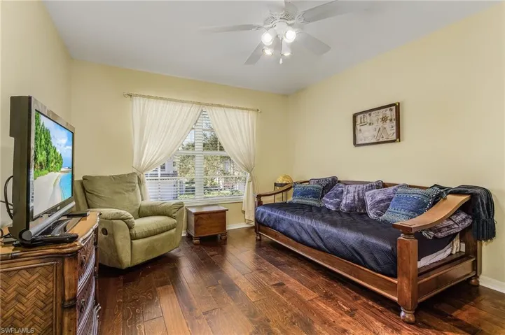 Living area featuring ceiling fan and dark hardwood / wood-style flooring