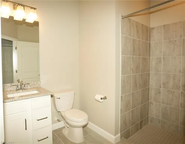 Bathroom featuring a white vanity with a speckled countertop, undermount sink, and brushed nickel faucet