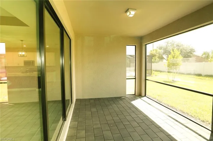 Screened patio featuring paver flooring, stucco walls, and a recessed ceiling light