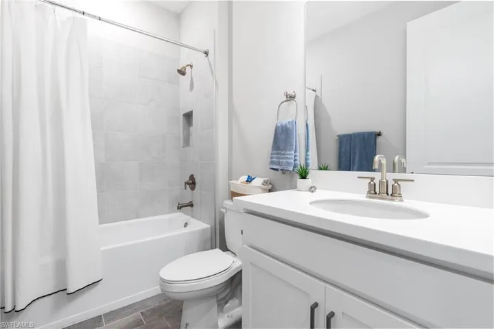 Bathroom with shower / tub combo with curtain and vanity