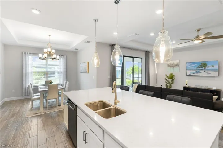 Kitchen featuring a raised ceiling, white cabinets, wood tiled floors, and recessed lighting
