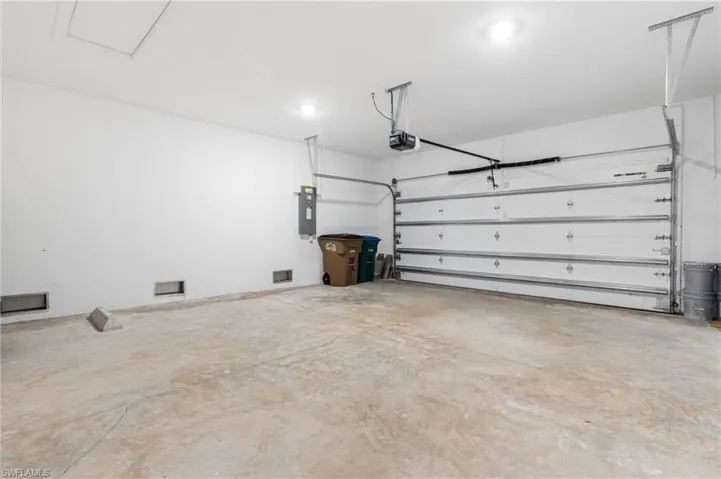 Garage featuring electric panel and a garage door opener