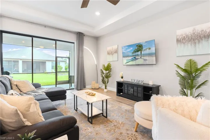 Living room featuring wood finished floors, ceiling fan, and recessed lighting
