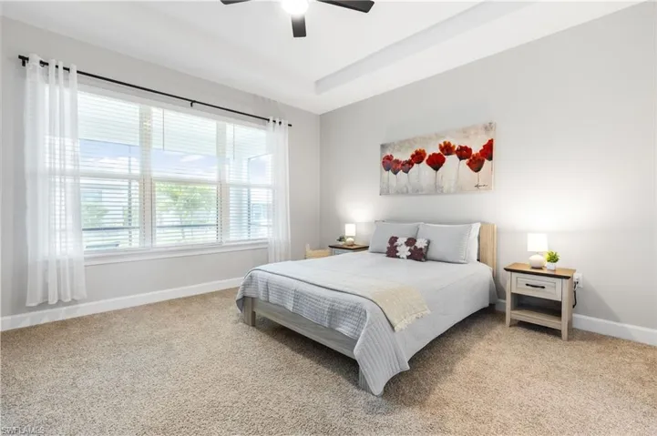 Bedroom with light carpet and a ceiling fan
