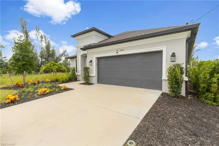 View of front of house featuring driveway, stucco siding, an attached garage, and roof with shingles