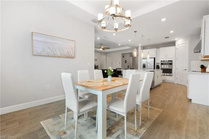 Dining space with a chandelier, light wood-style flooring, recessed lighting, and a ceiling fan