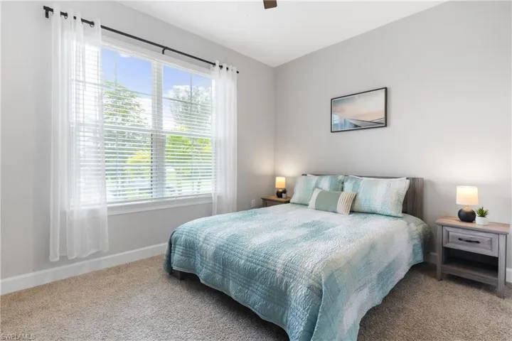 Carpeted bedroom with a ceiling fan and baseboards