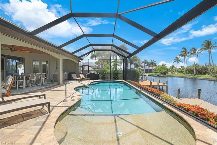 View of swimming pool featuring glass enclosure and a patio area