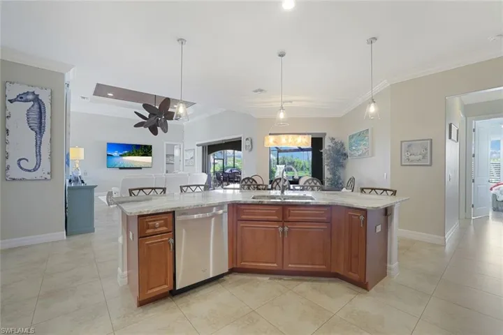 Kitchen with ceiling fan, dishwasher, pendant lighting, sink, and a kitchen island with sink