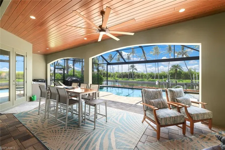 Sunroom featuring ceiling fan and wood ceiling