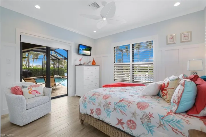 2nd Guest Bedroom on main level featuring ceiling fan, multiple windows, access to outside, and wood-type flooring