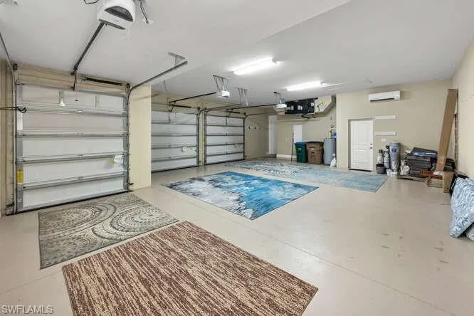 OVERSIZED 3 Car Garage featuring a garage door opener, an AC A/C wall unit