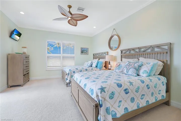 Carpeted 3rd Guest bedroom upstairs with 2 Queen Beds  and ornamental molding and ceiling fan