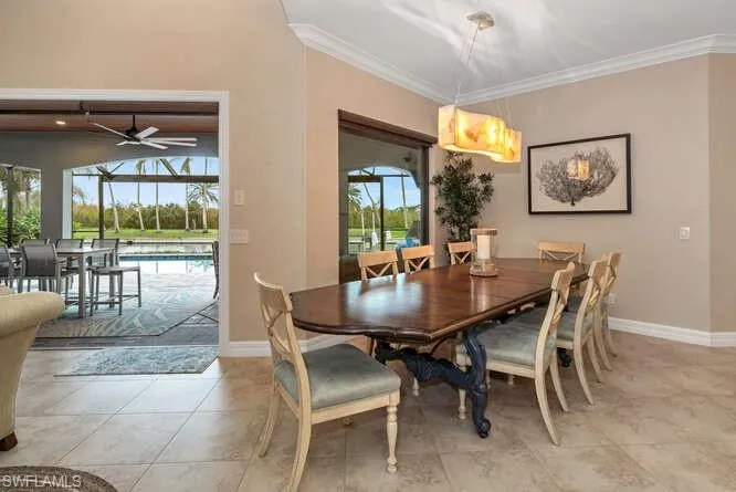 Tiled dining space with ceiling fan, crown molding, and a wealth of natural light